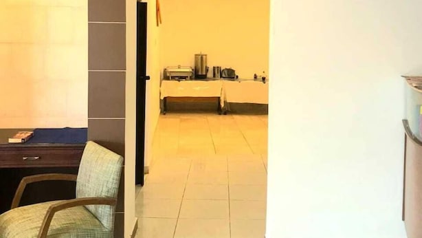 Ett modernt hotellrum med en matplats, ett kök och en sittgrupp med en stol och ett bord.