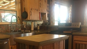 Una cucina rustica con mobili in legno, un frigorifero in acciaio inossidabile e una grande isola.