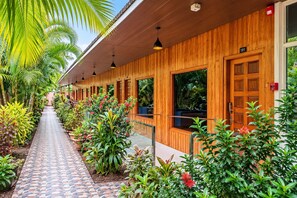 A wooden building with a covered walkway, potted plants, and a clear sky. - Hotel Golden Pebble (Port Blair)