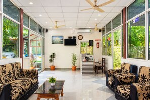 A spacious lobby with two sofas, a coffee table, and a staircase leading to an upper level. - Hotel Golden Pebble (Port Blair)