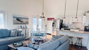 En moderne stue med sofa, sofabord og spiseplads.