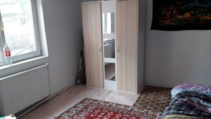 Une pièce comprenant une armoire, un radiateur, une fenêtre et un lit.