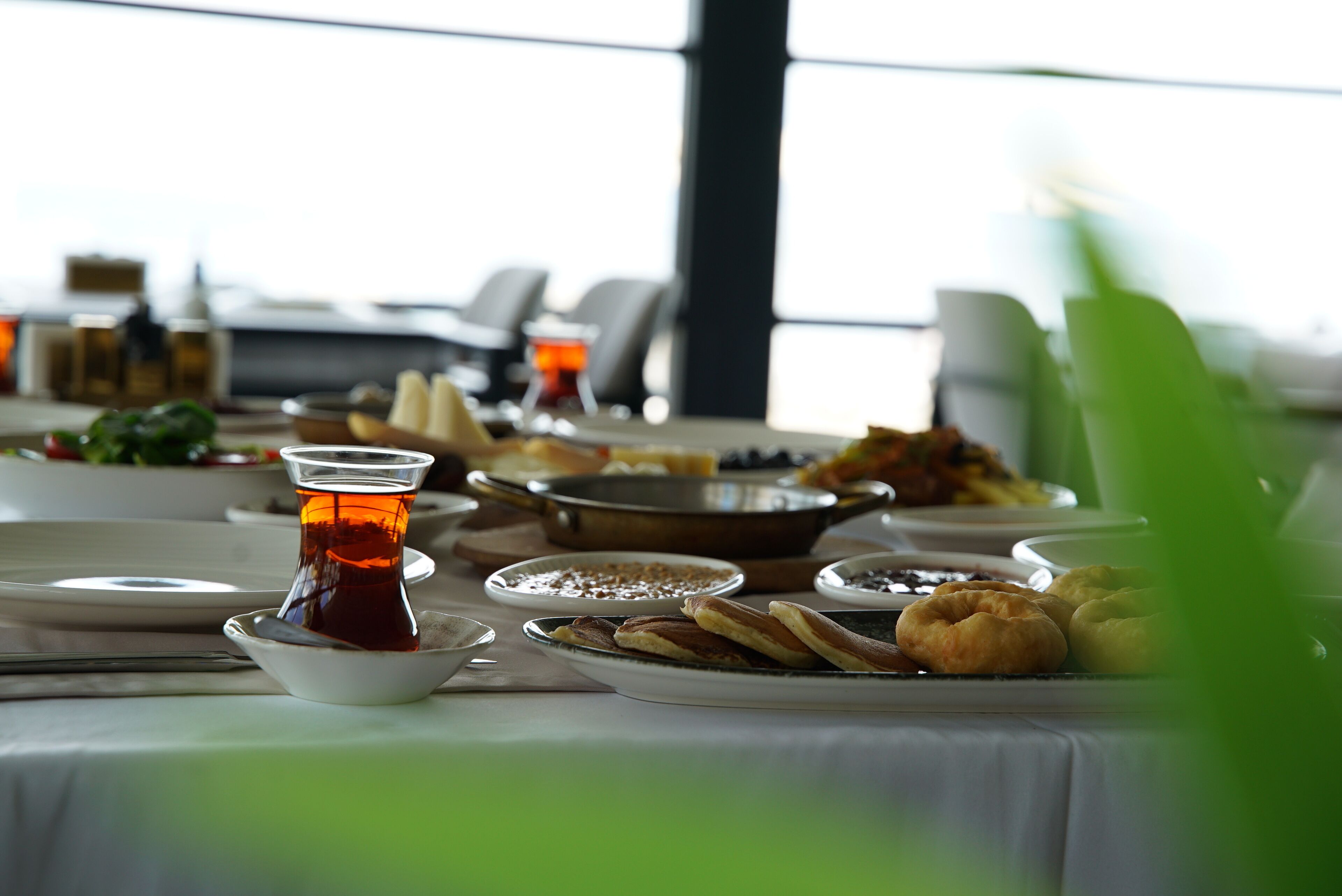 Una mesa de comedor con diversos platos, incluyendo una taza de té, fuentes de comida y una tetera.