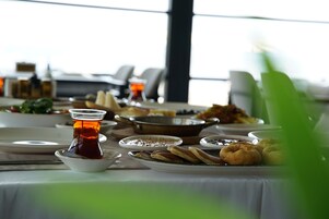 Una mesa de comedor con diversos platos, incluyendo una taza de té, fuentes de comida y una tetera.