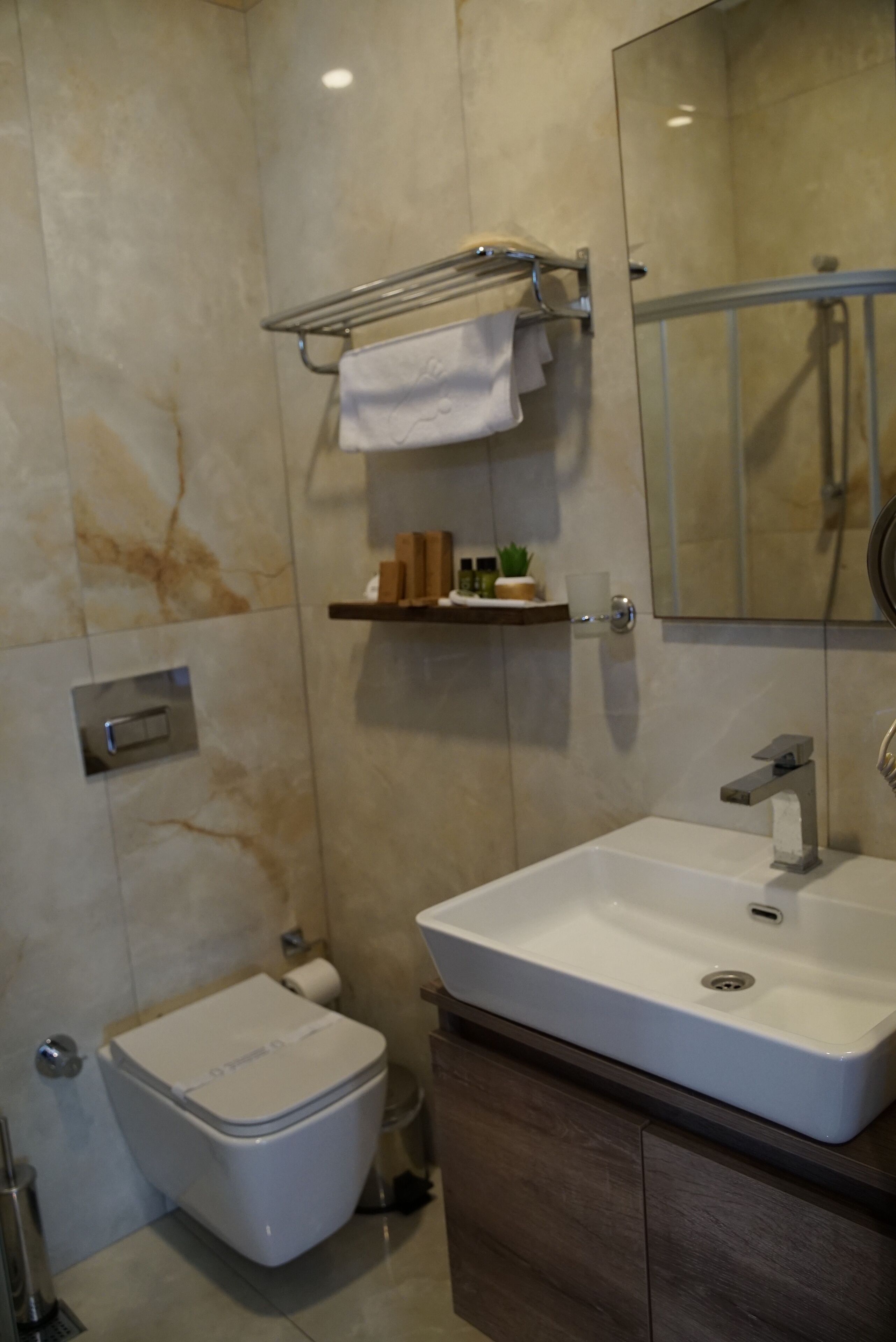 Un baño moderno con inodoro, lavabo y espejo.