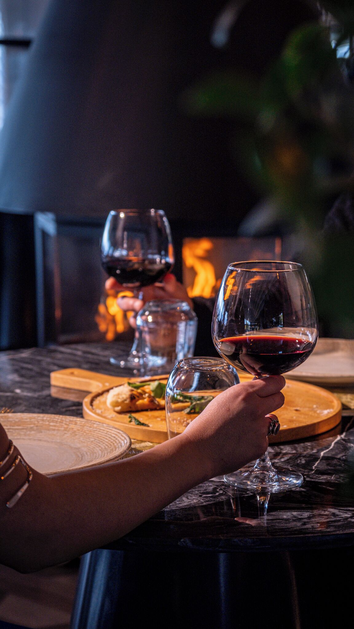 Una mesa con copas de vino y un plato de comida, evocando un ambiente de comedor.