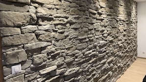 A stone wall with a thermostat.