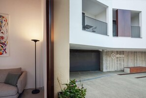 A modern interior with a sofa, floor lamp, and a potted plant. - Alinea Suites Limassol Center (Limassol)