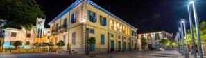 Un edificio histórico de varios pisos, con amplias ventanas y un balcón.
