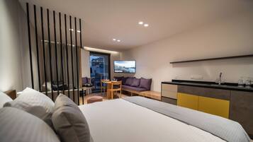 Una habitación de hotel moderna con una cama grande, un escritorio, un sofá y una televisión.