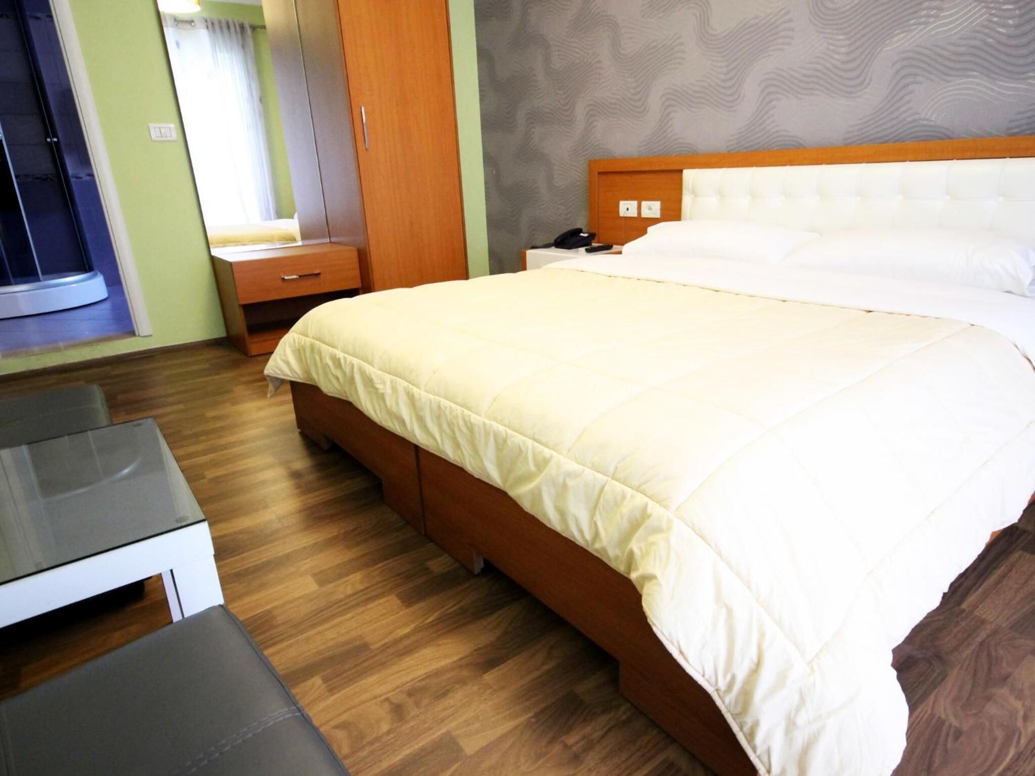 Una habitación de hotel con cama, mesita de noche y escritorio.