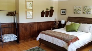 Un dormitorio con una cama de madera, una silla colgante y estantes con plantas en la pared.