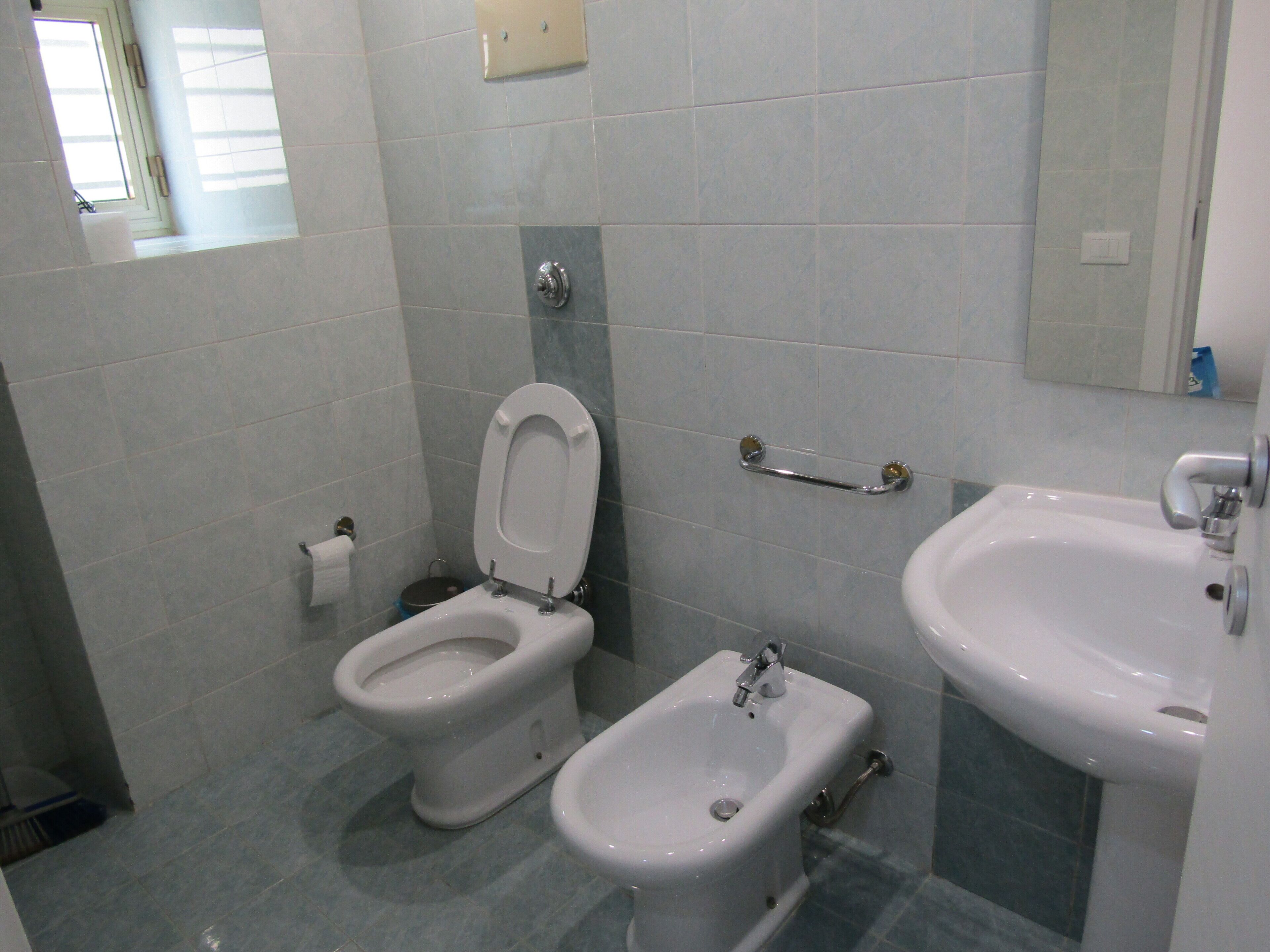 A bathroom with a toilet, bidet, and sink.
