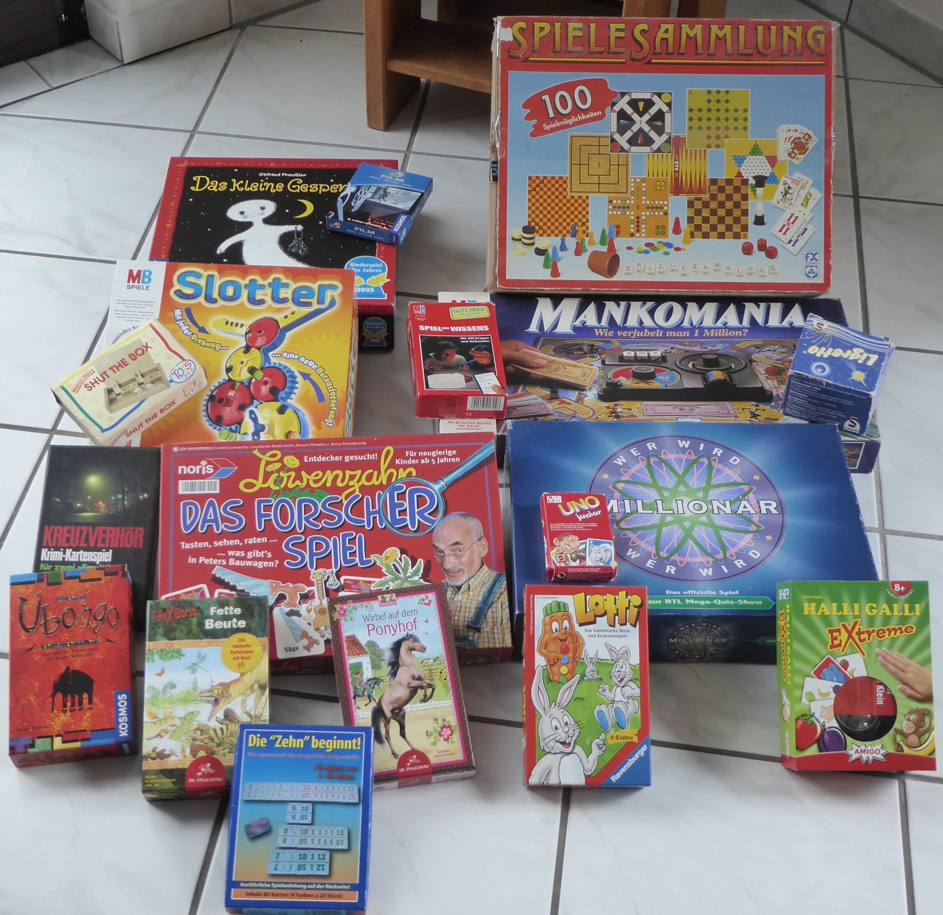 Verschillende gezelschapsspellen liggen uitgespreid op een betegelde vloer.