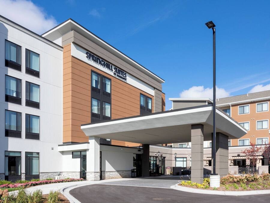A modern hotel with a prominent entrance, large windows, and a covered outdoor area.