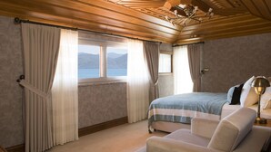 Un dormitorio con cama, una silla y vistas al exterior.