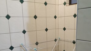 A corner of a room with a tiled wall featuring a geometric pattern. - Apartment across from UFV with garage. (Centro)