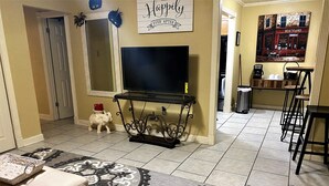 A living room with a TV, a sofa, a coffee table, and a patterned rug. - 2 Blocks to LSU Gameday Shuttle. Best Downtown Location By Far (Baton Rouge)