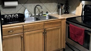 A kitchen with wooden cabinets, a stainless steel sink, a stove, and an oven. - 2 Blocks to LSU Gameday Shuttle. Best Downtown Location By Far (Baton Rouge)
