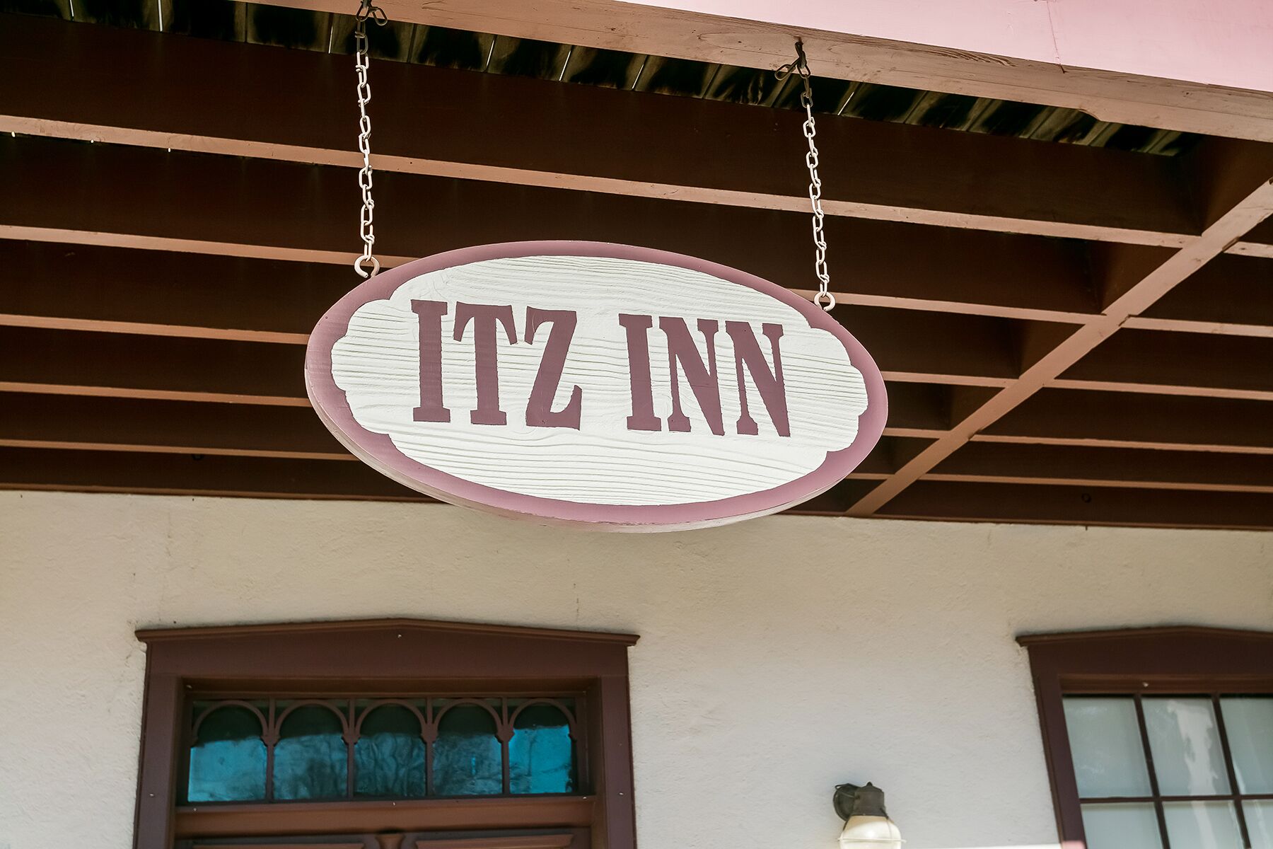 A hanging sign with the name "ITZ INN" in a stylized font, indicating the name of the establishment.