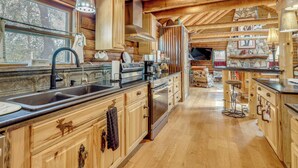 Una cocina amplia con armarios de madera, una isla grande y una pared de piedra.
