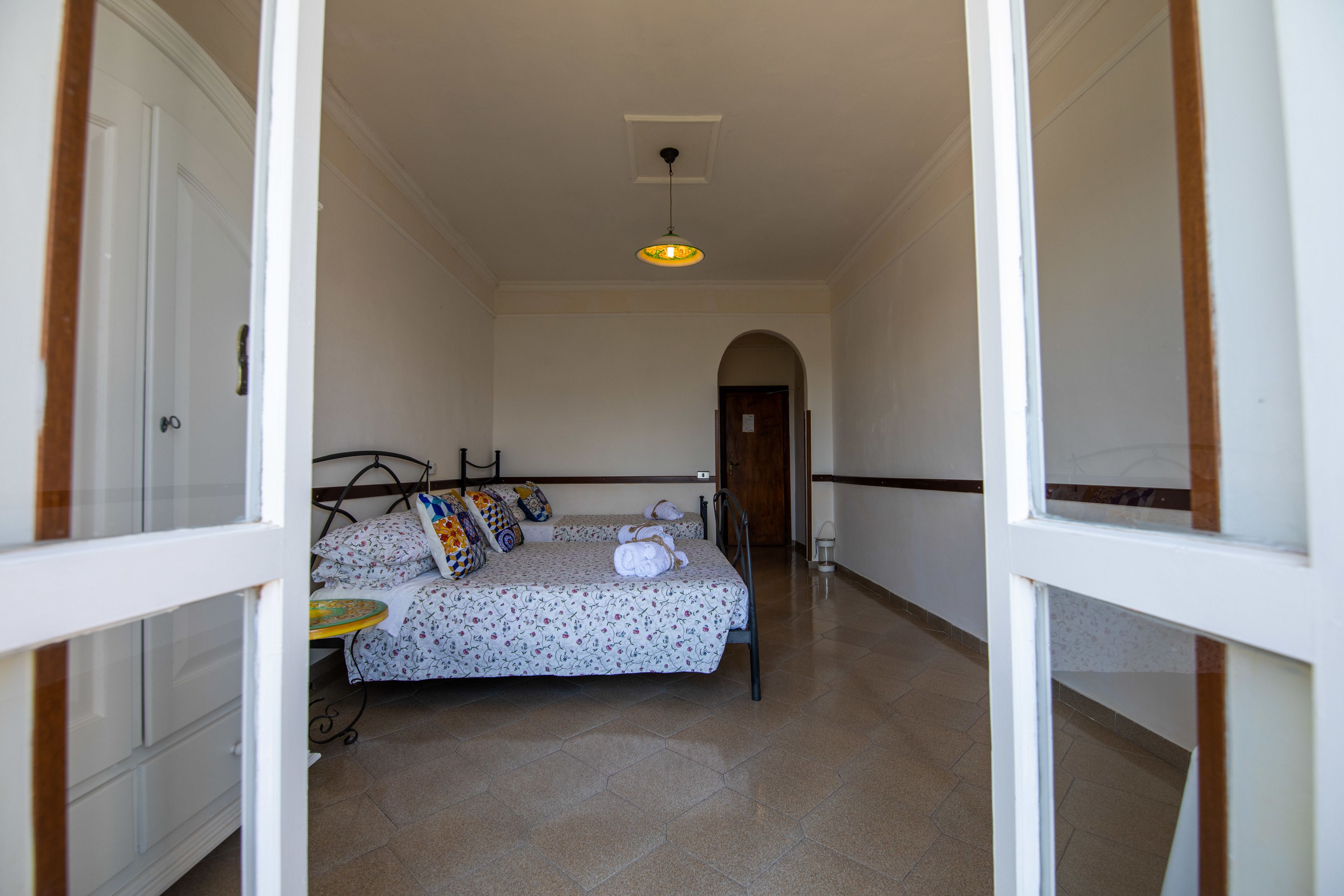 Ein Schlafzimmer mit Bett, Nachttisch und einer Pendelleuchte.