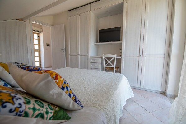 Une chambre à coucher avec un lit, un bureau et une télévision.