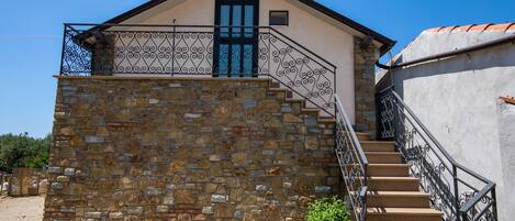 Ein Gebäude aus Stein mit einem Balkon und einer Treppe.