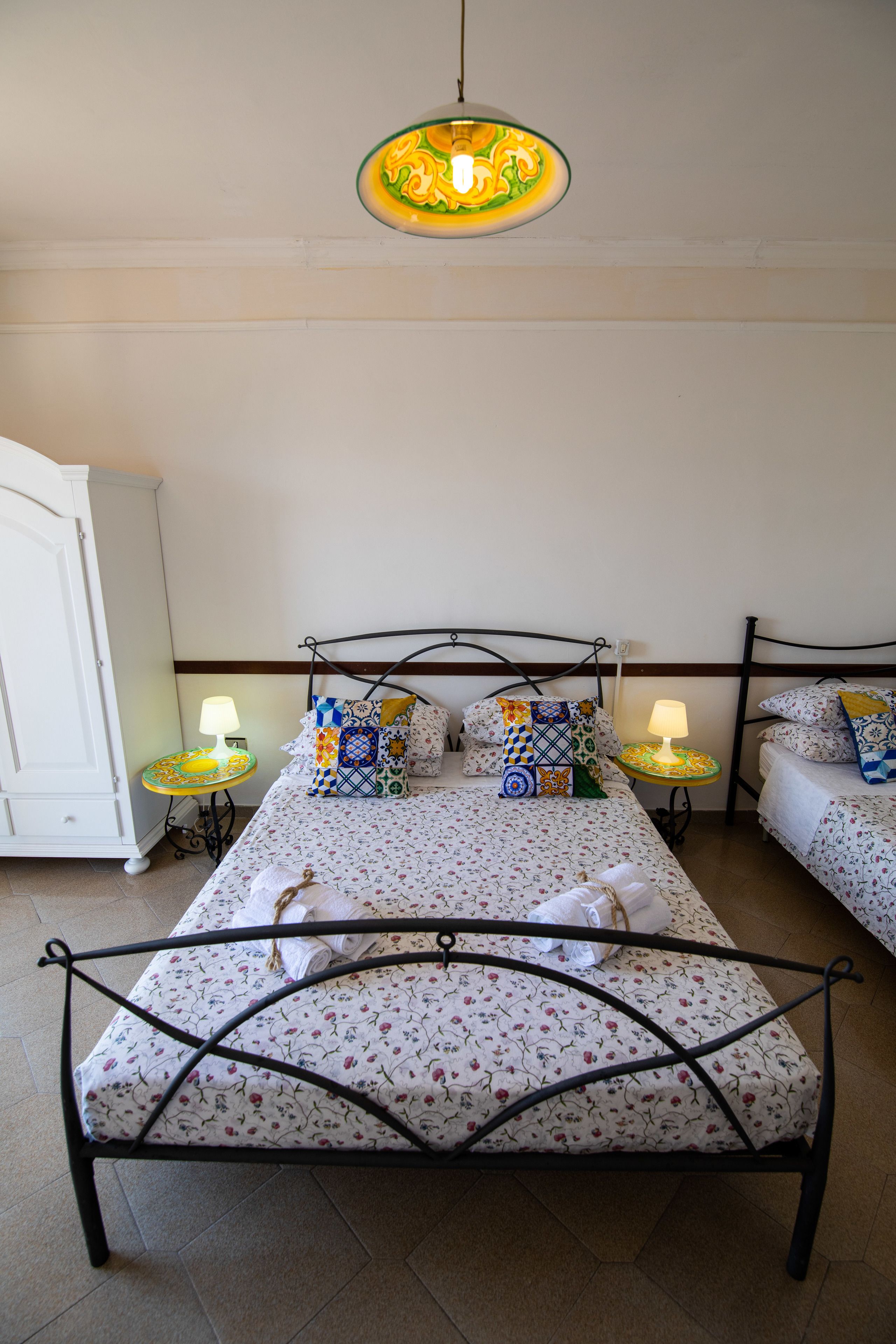 A bedroom with a bed, two bedside tables, a lamp, and a wardrobe.