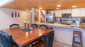 A modern kitchen with a wooden ceiling, built-in appliances, and a central island.