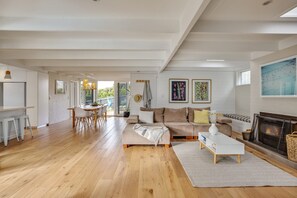 A spacious living area with a wooden floor, a sofa, a coffee table, and a fireplace. - FABULOUS FOAM COASTAL HOLIDAY HOME, SOLAR POOL & ENTERTAINER, BLAIRGOWRIE (Blairgowrie)