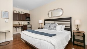 Une chambre d’hôtel équipée d’un lit, de tables de chevet, d’un bureau, d’un four à micro-ondes et d’un miroir.