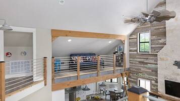 Relax in a spacious living area with a loft bedroom, featuring a dining area and fireplace.