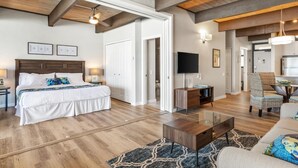 A spacious living room with a large bed, a TV, and a dining area.