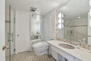 Un baño moderno con un espejo grande, un lavabo y un inodoro.