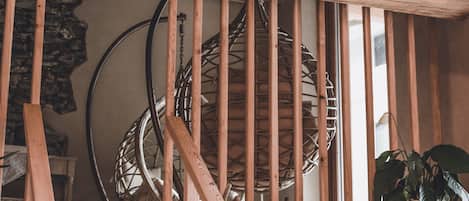 Una escalera de madera con una cesta tejida y cerámica en la barandilla.