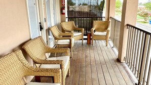 A covered porch with wicker furniture and a fire extinguisher. - Marfa House La Junta: In the center of Marfa (Marfa)