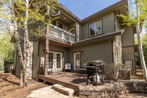 A two-story house with a covered patio, a barbecue grill, and a stone wall. - Hiking, Fishing, Biking, Skiing all within the valley 30 min from Jackson Hole (Victor)