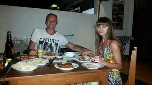 A dining table with plates of food, a bottle of beer, and a glass of a yellowish beverage. - Dasa Beach View (Koggala)