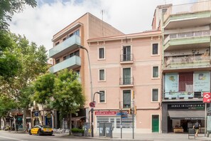 Stylish building with a mix of balconies and windows, home to various businesses.