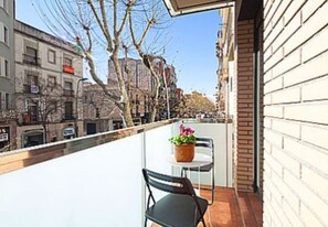 Enjoy the city view from this balcony with a table and chairs, perfect for taking in the sights.