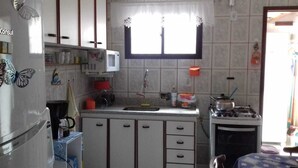Une cuisine compacte équipée d’un réfrigérateur, d’un four à micro-ondes, d’un évier et d’une cuisinière.