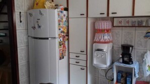 Une cuisine équipée d’un réfrigérateur, d’un distributeur d’eau et d’une machine à café.