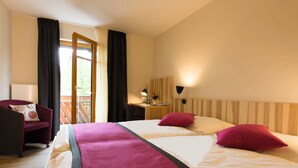 Una habitación de hotel con cama, escritorio, silla y vistas al exterior.