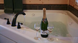 Een fles Andre champagne en twee glazen op een badkamermeubel.