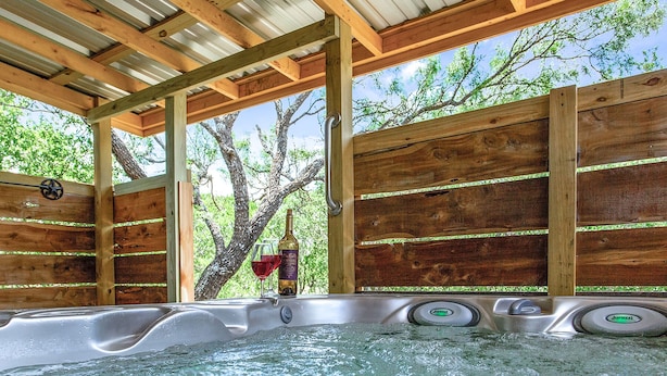 Een hottubgedeelte met houten wanden en uitzicht op bomen.