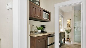 Una cocina moderna con armarios de madera oscura, un refrigerador de acero inoxidable y una cafetera en la encimera.