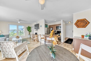 Un salon moderne avec une table à manger, un canapé et une vue sur la ville.
