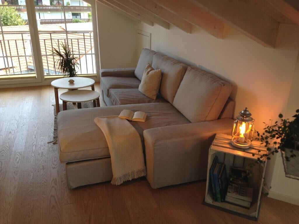 A cozy living room with a sofa, a small round table, and a bookshelf.