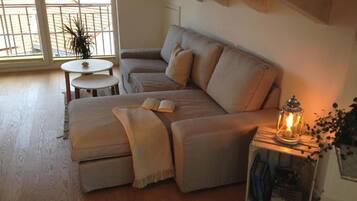 A cozy living room with a sofa, a small round table, and a bookshelf.